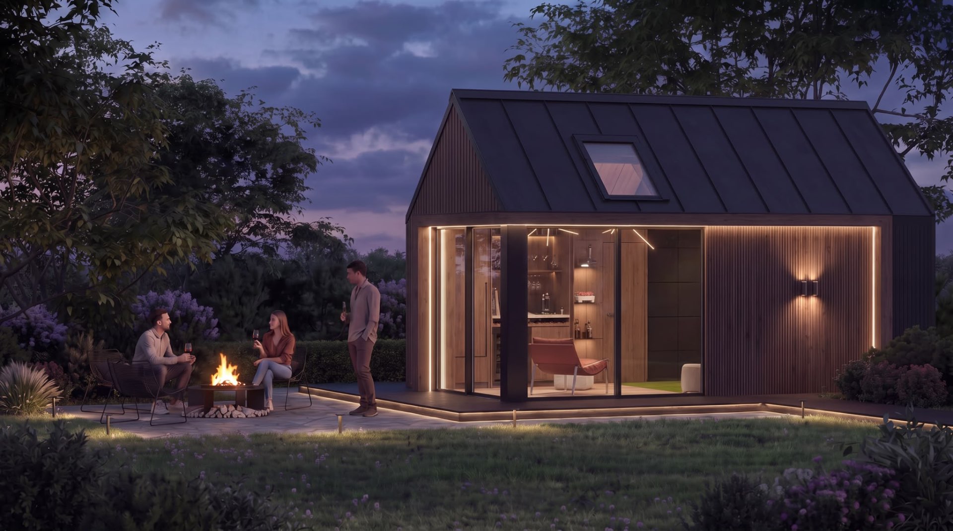 Friends enjoying an evening around the fire outside an illuminated Skalva garden room